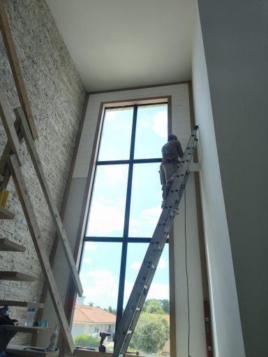 Two-story tongue-and-groove wall surrounding a tall window beside a stone accent wall.