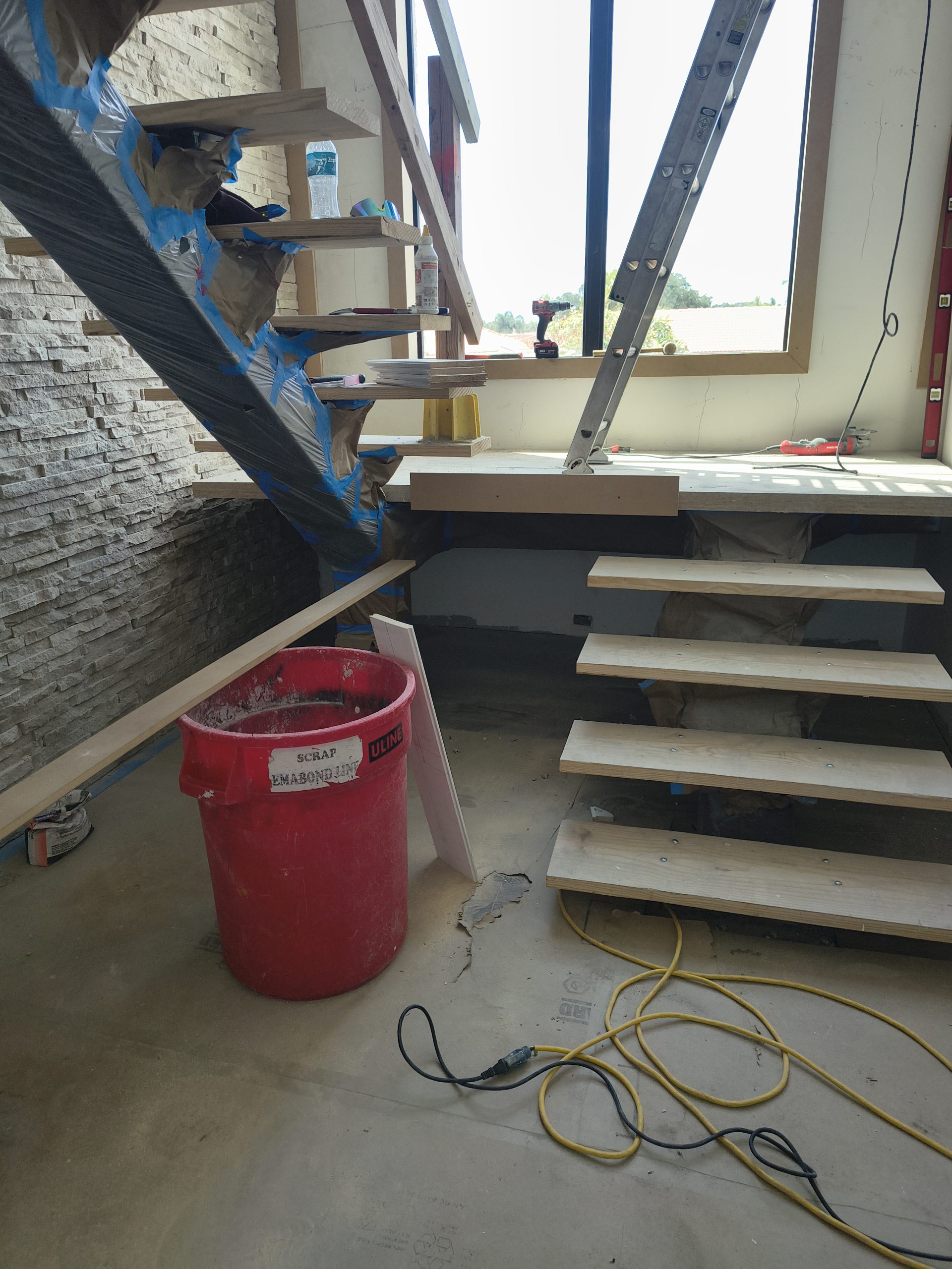 Temporary steel stair landing blocking access to the lower tongue-and-groove wall.