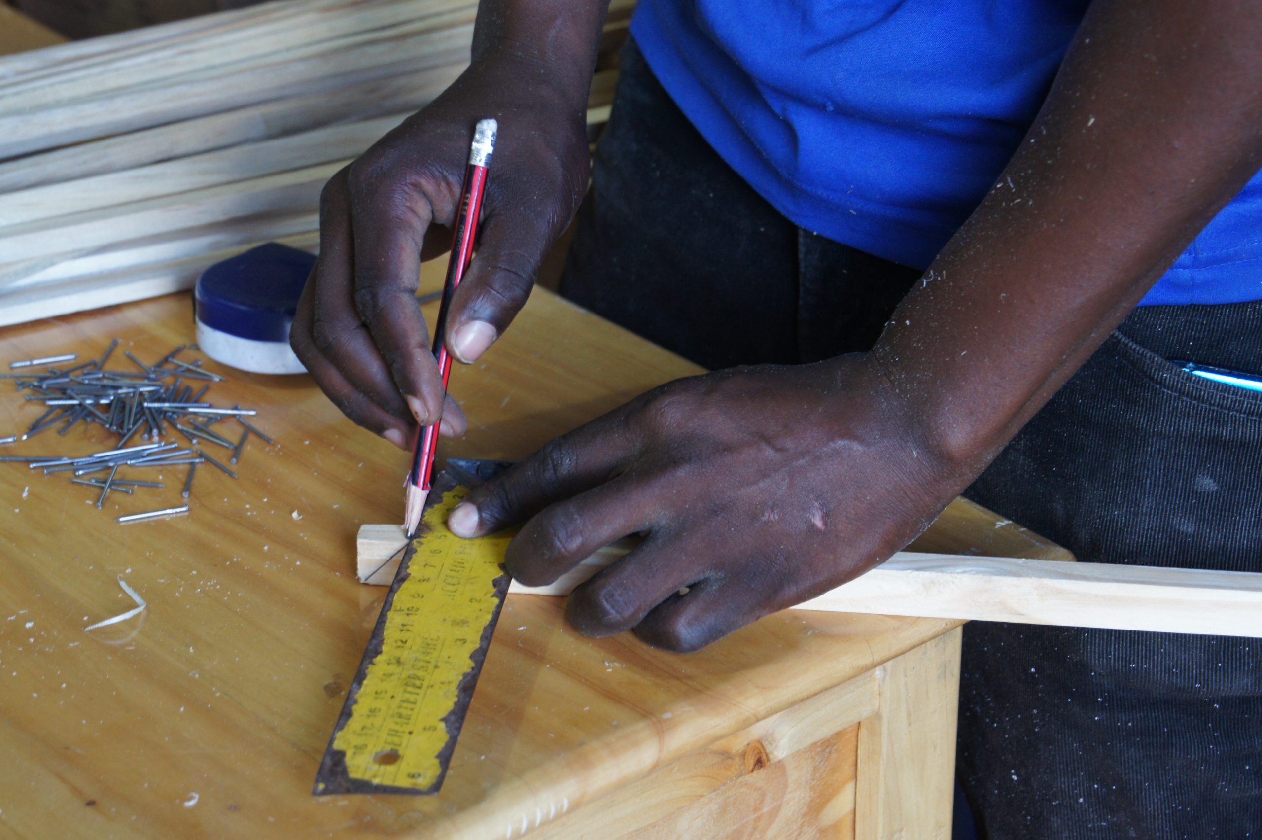 Carpenter measuring and marking timber before cutting during project layout