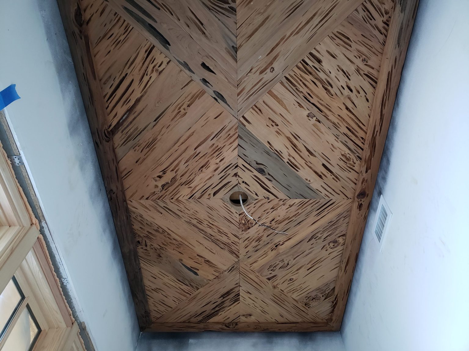 Pecky cypress tongue and groove tray ceiling with diagonal boards meeting in an X pattern